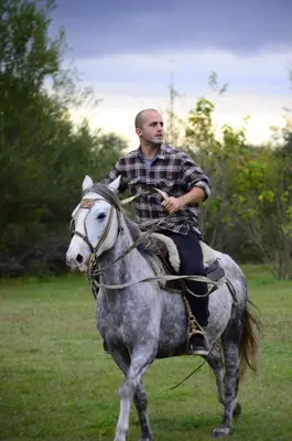a man riding a horse in a field at Rancho La Peregrina in Nono