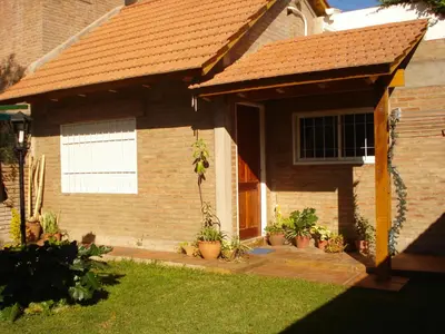 a brick house with a porch with potted plants at Departamento carlos paz in Villa Carlos Paz