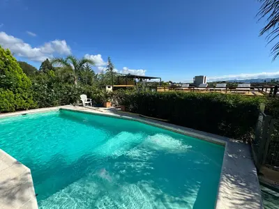 a swimming pool with blue water in a yard at Vivaldi Suites in Villa Carlos Paz