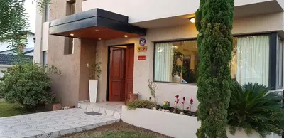 a house with a tree in front of it at Vivaldi Suites in Villa Carlos Paz