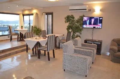a dining room with tables and chairs and a tv at Vivaldi Suites in Villa Carlos Paz