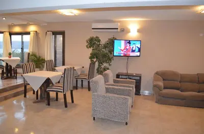 a living room with tables and chairs and a flat screen tv at Vivaldi Suites in Villa Carlos Paz