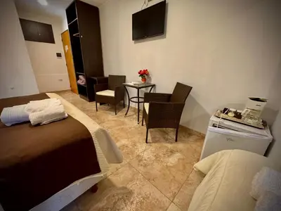 a hotel room with two beds and a table and chairs at Vivaldi Suites in Villa Carlos Paz