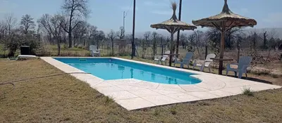 a swimming pool with a table and chairs and an umbrella at A Dolce Vita in Nono