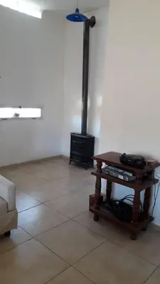 a living room with a table and a stove at La Casa de Patis in Villa Carlos Paz