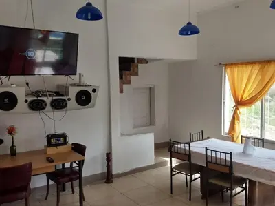a dining room with a table and a tv on the wall at La Casa de Patis in Villa Carlos Paz