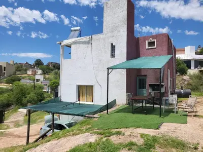 a house with a tennis court and a ping pong table at La Casa de Patis in Villa Carlos Paz