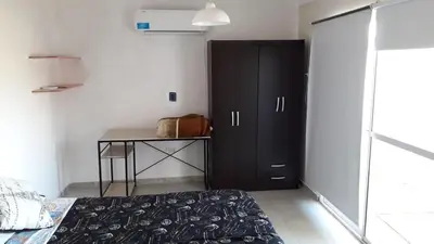 a bedroom with a black cabinet and a table at La Casa de Patis in Villa Carlos Paz
