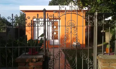 a gate to a house with a building behind it at Casa de Silvia in Villa Carlos Paz