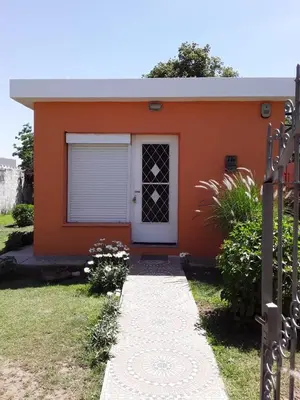 a small orange house with a white door at Casa de Silvia in Villa Carlos Paz