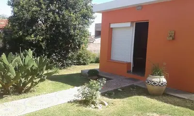 an orange house with two plants in front of it at Casa de Silvia in Villa Carlos Paz