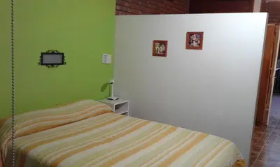 a bedroom with a bed and a tv on a wall at Casa de Silvia in Villa Carlos Paz