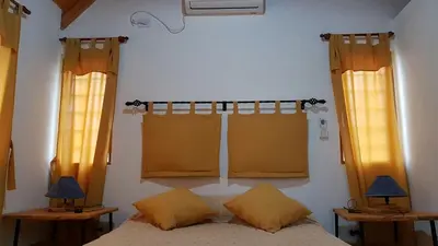 a bedroom with two windows and a bed with two lamps at Brujas in Los Reartes
