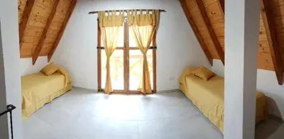 two beds in a room with a window at Brujas in Los Reartes