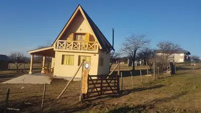a small house in a field next to a fence at Brujas in Los Reartes