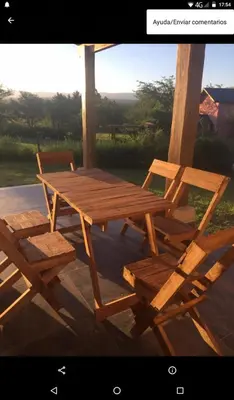 a wooden picnic table and chairs on a porch at Brujas in Los Reartes