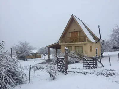 a house covered in snow in a yard at Brujas in Los Reartes