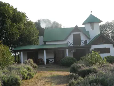 a white house with a green roof at Finca La Julia in Luyaba