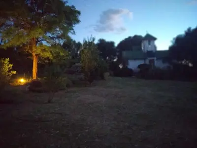 a night view of a yard with a house in the background at Finca La Julia in Luyaba