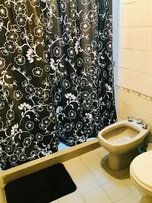 a bathroom with a black shower curtain and a toilet at Ganesha in Villa Carlos Paz