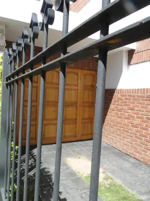 a metal fence with a wooden garage door at Ganesha in Villa Carlos Paz