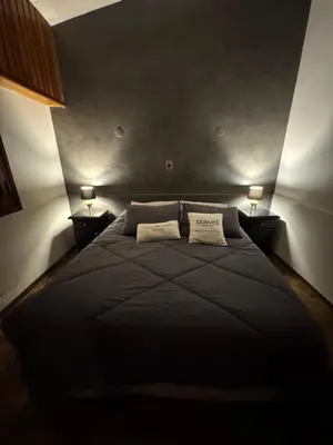 a large black bed in a room with two lamps at Ganesha in Villa Carlos Paz
