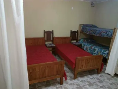 a room with two beds with red sheets and a bedsenalsenalsenalsenalangering at Malvina in Villa Icho Cruz