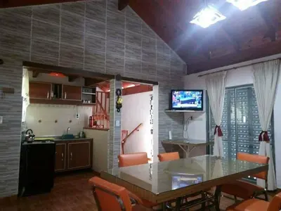 a kitchen and dining room with a table and a television at Malvina in Villa Icho Cruz