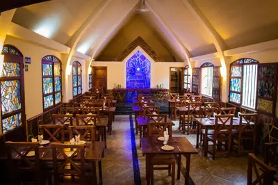 an empty dining room with tables and stained glass windows at Capilla del Lago in Villa Carlos Paz