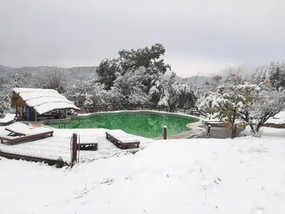 a swimming pool covered in snow next to a house at Capilla del Lago in Villa Carlos Paz