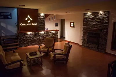 a lobby of a hotel with chairs and a fireplace at Capilla del Lago in Villa Carlos Paz