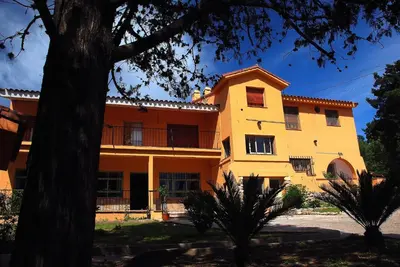 a yellow house with a tree in front of it at Capilla del Lago in Villa Carlos Paz