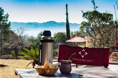 a picnic table with a thermos and a basket of bread at Capilla del Lago in Villa Carlos Paz
