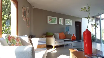 a living room with a couch and a red vase at Harmonie Hotel De Montaña - Adults only in Villa General Belgrano