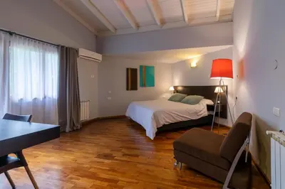 a bedroom with a bed and a couch and a table at Harmonie Hotel De Montaña - Adults only in Villa General Belgrano