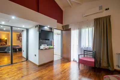 a living room with a couch and a television in a room at Harmonie Hotel De Montaña - Adults only in Villa General Belgrano