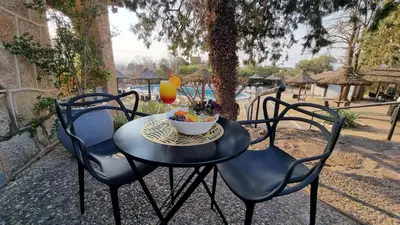 a table and chairs with a bowl of fruit on it at Pinares del Cerro Resort & Suites in Villa Carlos Paz