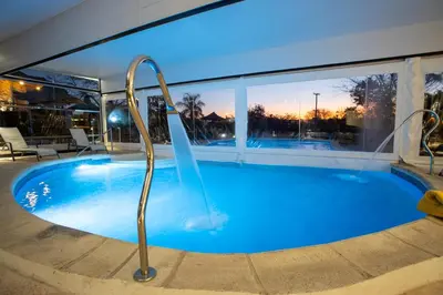 a swimming pool with a water slide in a building at Pinares del Cerro Resort & Suites in Villa Carlos Paz