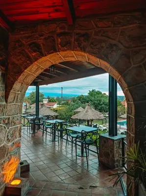 an archway in a building with tables and chairs at Pinares del Cerro Resort & Suites in Villa Carlos Paz