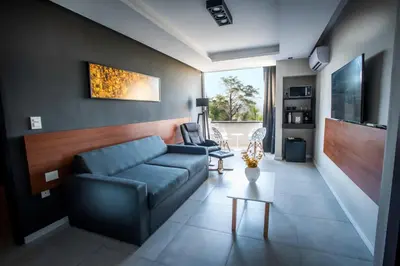 a living room with a blue couch and chairs at Pinares del Cerro Resort & Suites in Villa Carlos Paz