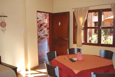 a dining room with a table and chairs and a window at Apart Hotel El Portico in Villa Carlos Paz