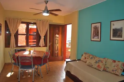 a living room with a table and a couch at Apart Hotel El Portico in Villa Carlos Paz