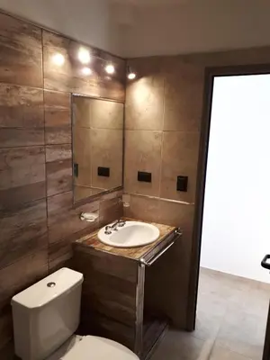 a bathroom with a toilet and a sink and a mirror at Kawsay Complejo de Cabañas in San Antonio de Arredondo