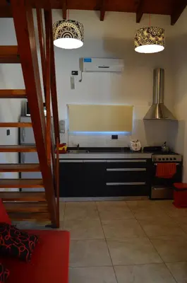a kitchen with black cabinets and a stove at Kawsay Complejo de Cabañas in San Antonio de Arredondo