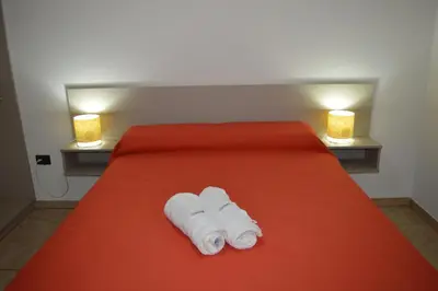 a bed with two towels on it with two lights at Kawsay Complejo de Cabañas in San Antonio de Arredondo
