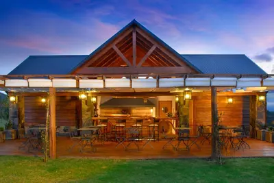 a house with a deck with tables and chairs at Chamonix Posada & Spa in Villa General Belgrano