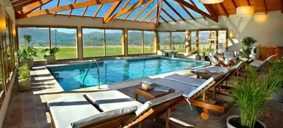 a pool in a house with chairs and a table at Chamonix Posada & Spa in Villa General Belgrano