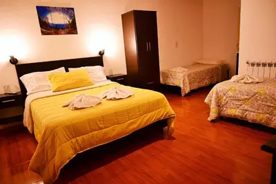 a bedroom with two beds with yellow sheets at Posada Inguz in Villa Berna