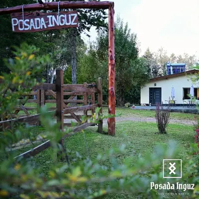 a wooden fence in a yard with a house at Posada Inguz in Villa Berna