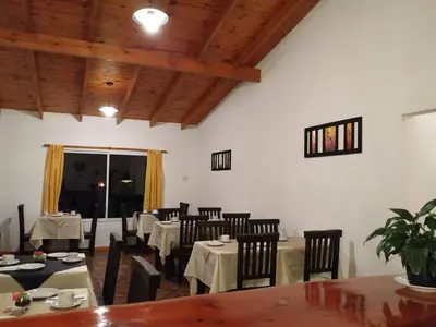 a dining room with tables and chairs and wooden ceilings at Posada Inguz in Villa Berna